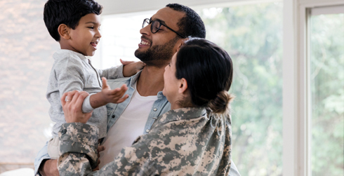 A man and a woman with a younger child. The woman is wearing a military uniform.