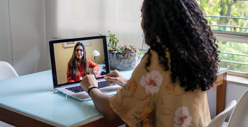 Person sitting in front of a laptop having a telehealth session