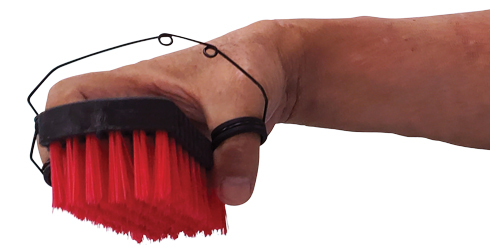 Hand with wire splint holding red scrub brush
